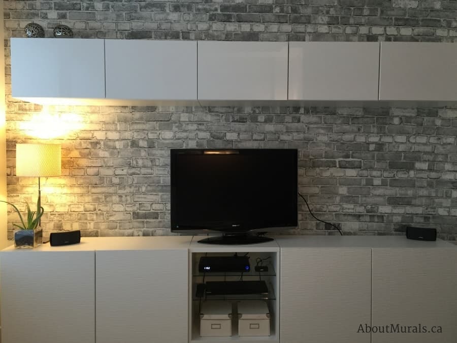 Old Brick Wall Mural Black and White, as seen in this TV room, is a grey brick wallpaper sold by AboutMurals.ca.