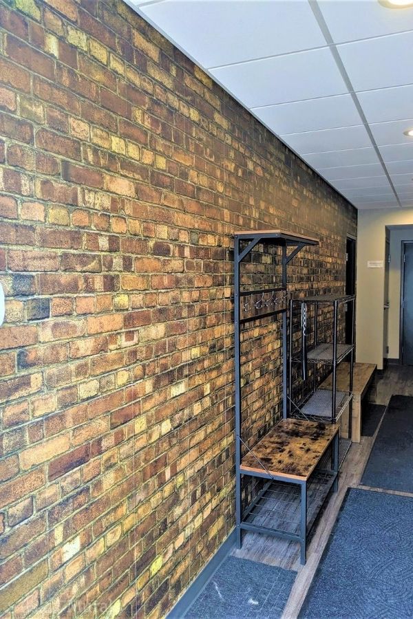 Old Brick Wall Mural, as seen in this hallway, features rustic looking red brick. Brick wallpaper sold by AboutMurals.ca.