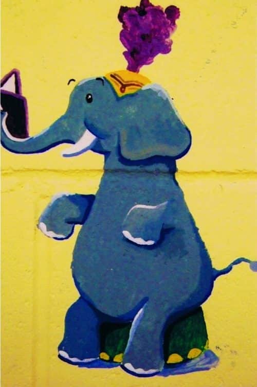 A circus mural featuring an elephant reading a book, painted by Adrienne of AboutMurals.ca