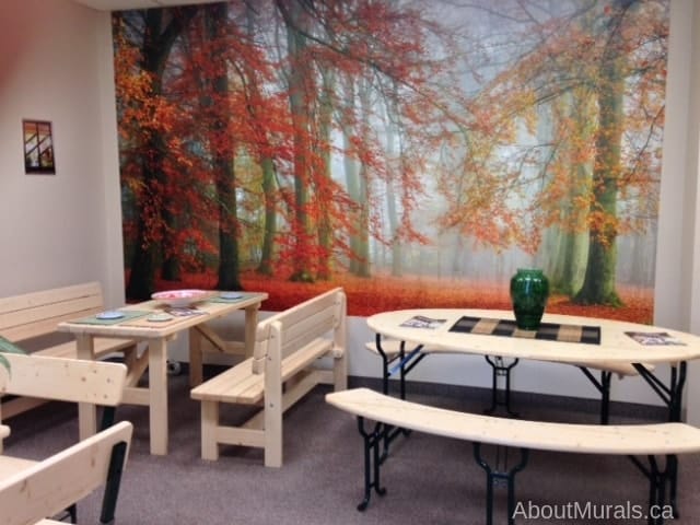 Autumn Season Wallpaper, as seen on the wall of this dining room, is a photo wallpaper of orange trees and textured leaves hanging over a leafy path against a grey misty background from About Murals.