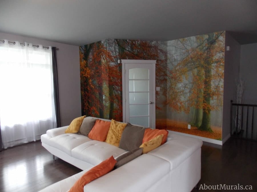 Autumn Season Wallpaper, as seen on the wall of this living room, is a photo wallpaper of orange trees hanging over a romantic path leading toward a foggy forest from About Murals.