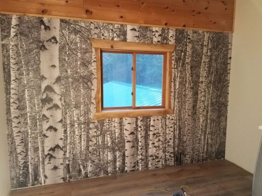 Birch Tree Forest Black and White Wall Mural, as seen on the wall of this cottage, is a photo wall mural of tree trunks in a forest from About Murals.