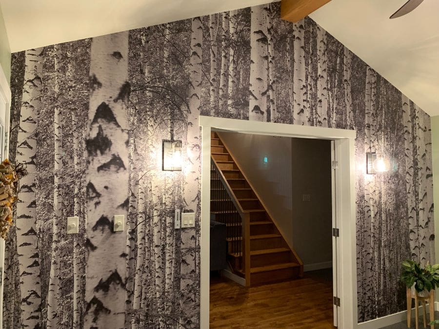Black and White Birch Tree Wallpaper, as seen on the wall of this sunroom, is a photo wallpaper mural of silver birch trees in a forest from About Murals.
