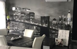 Brooklyn Bridge at Night Wall Mural, as seen in this dining room, features a black and white cityscape of the famous New York icon. Cityscape wallpaper from AboutMurals.ca.