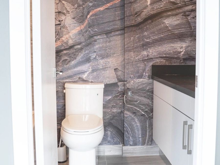 Canadian Shield Swirl Wall Mural, as seen in this bathroom, is a high resolution photo wallpaper of a grey rock face from About Murals.