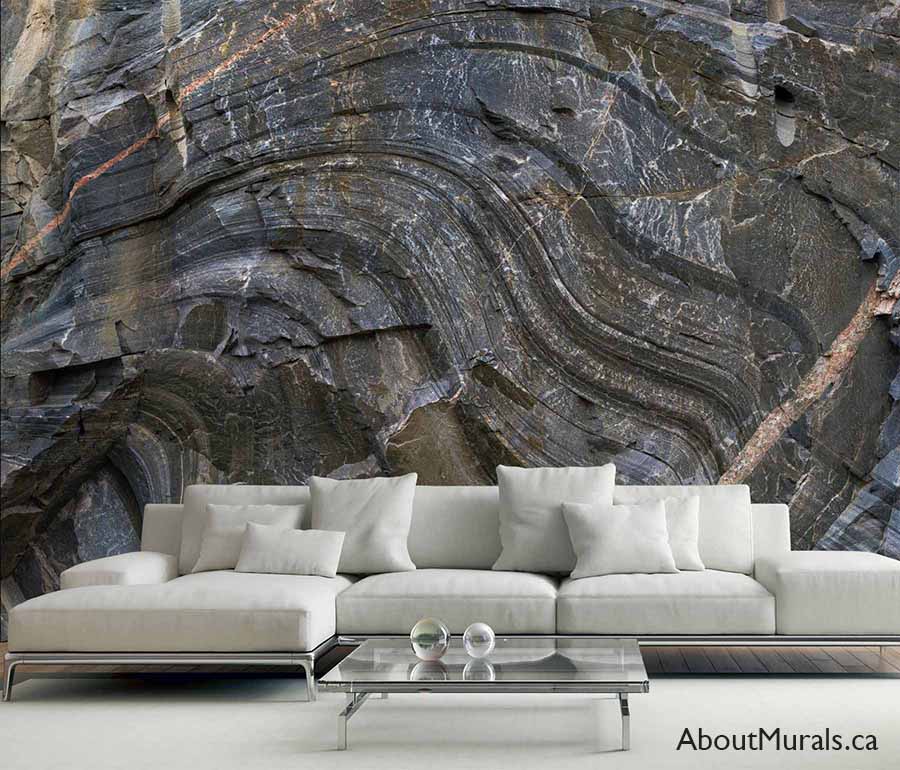 Canadian Shield Swirl Wall Mural, as seen on the wall of this living room, is a photo wallpaper of a realistic looking grey rock wall from About Murals.