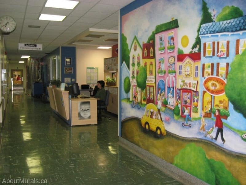 Candy Street Wall Mural, as seen in this hospital hallway, features a street of children's favourite shops - a bakery, circus school, toy store, pet shop and candy shoppe. Kids wallpaper sold by AboutMurals.ca.
