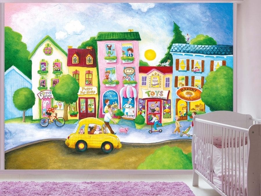 Children’s Town Wallpaper Mural, as seen on the wall of this nursery, is a hand-painted mural that is scanned and printed onto wallpaper featuring people walking pets down the street of a cartoon village from About Murals.