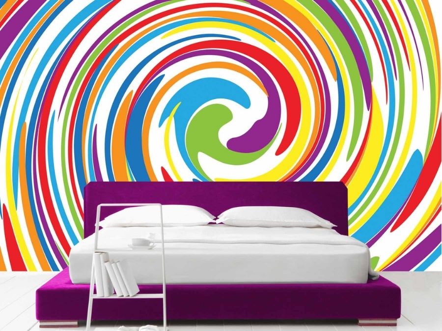 Colorful Swirl Wallpaper, as seen on the wall of this bedroom, is a rainbow coloured, hypnotic spiral from About Murals.