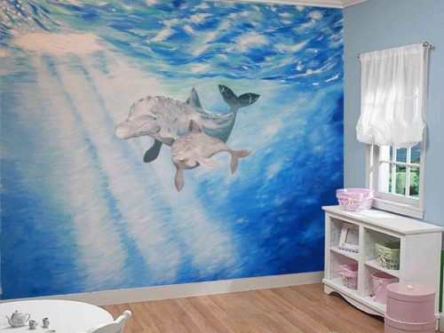 Dolphin Wallpaper, as seen on the wall of this bedroom, is a kids mural of a mom and baby dolphin swimming under the sea from About Murals.