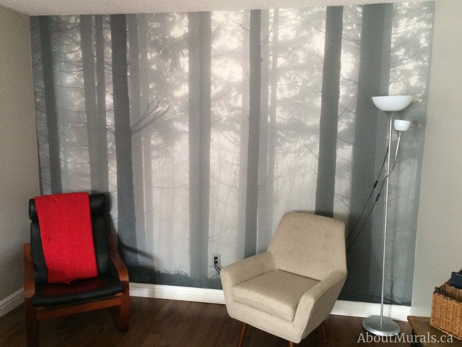 Fir Forest Wallpaper, as seen in this living room, features mysterious and misty grey trees in a forest. Forest wallpaper sold by AboutMurals.ca.