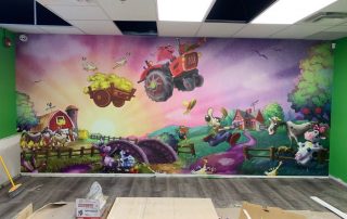 Funny Farm Wall Mural, as seen in this indoor playground, features a pig flying a tractor with a cow, horse, donkey and ducks laughing from About Murals.