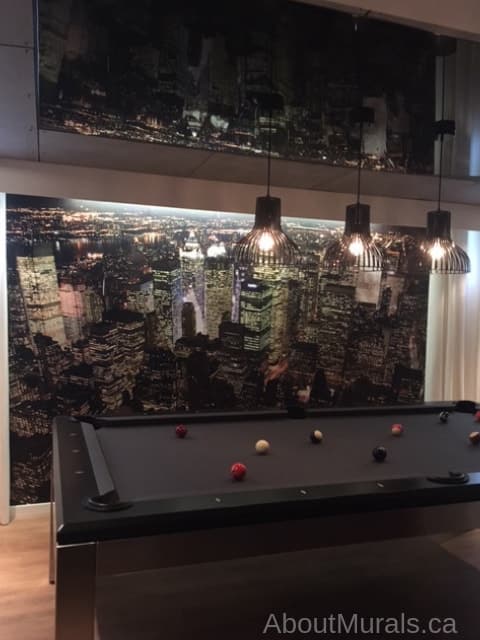 Manhattan at Night Wallpaper, as seen in this billiards room, features the New York skyline. Cityscape wallpaper sold by About Murals.