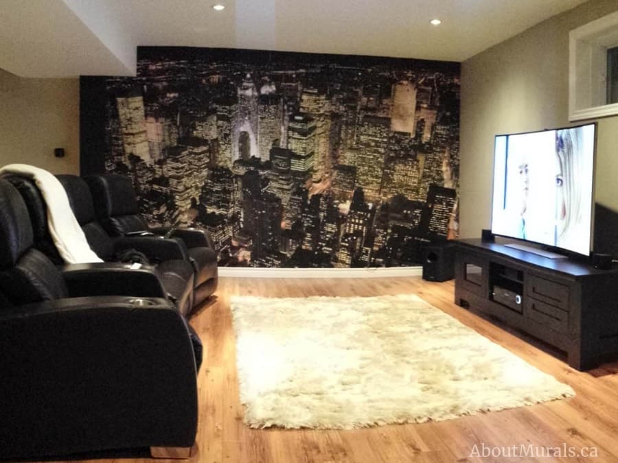Manhattan at Night Wallpaper, as seen in this TV room, features a nighttime aerial view of the New York City skyline from About Murals.