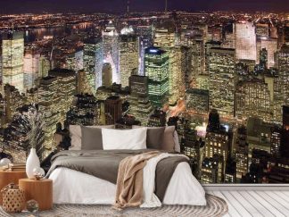 Manhattan at Night Wallpaper, as seen on the wall of this bedroom, is an aerial photo mural of modern lit skyscrapers in New York City under a black night sky from About Murals.
