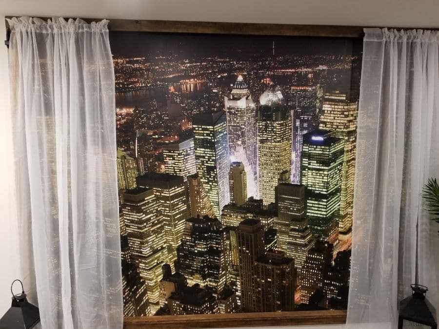 Manhattan at Night Wallpaper, as seen on the wall of this basement, is used to create a faux window scene. Cityscape wallpaper from About Murals.