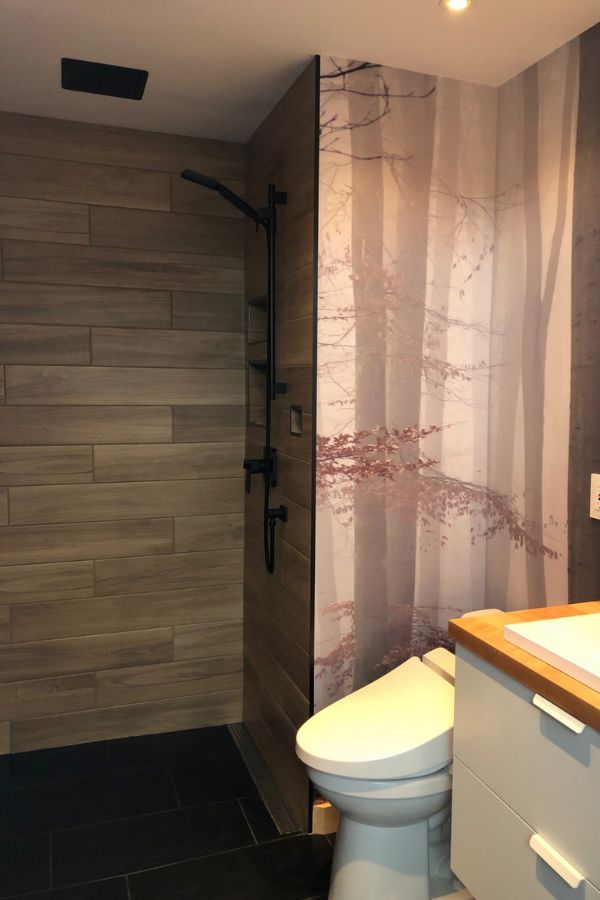 Morning Fog Wallpaper, as seen on the wall of this luxury bathroom, is a photo wall mural of grey misty trees in an autumn forest from About Murals.