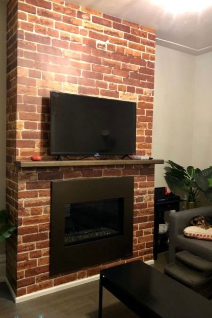 Not Just Another Brick on the Wall Mural, as seen on this fireplace, is a red brick wallpaper from About Murals.
