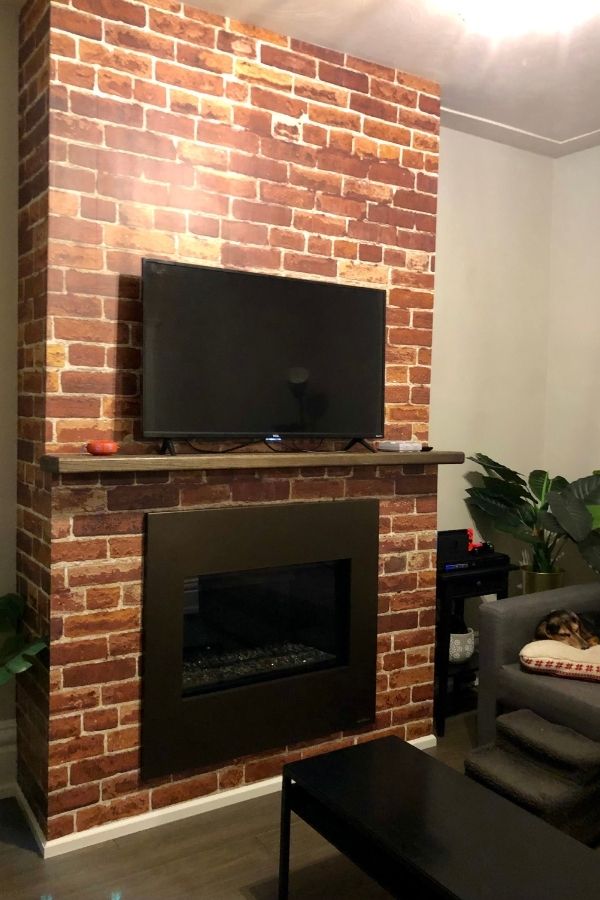 Orange Brick Wallpaper, as seen on the wall of this fireplace chimney breast, is a high res photo wall mural of a vintage brick wall full of texture from About Murals.