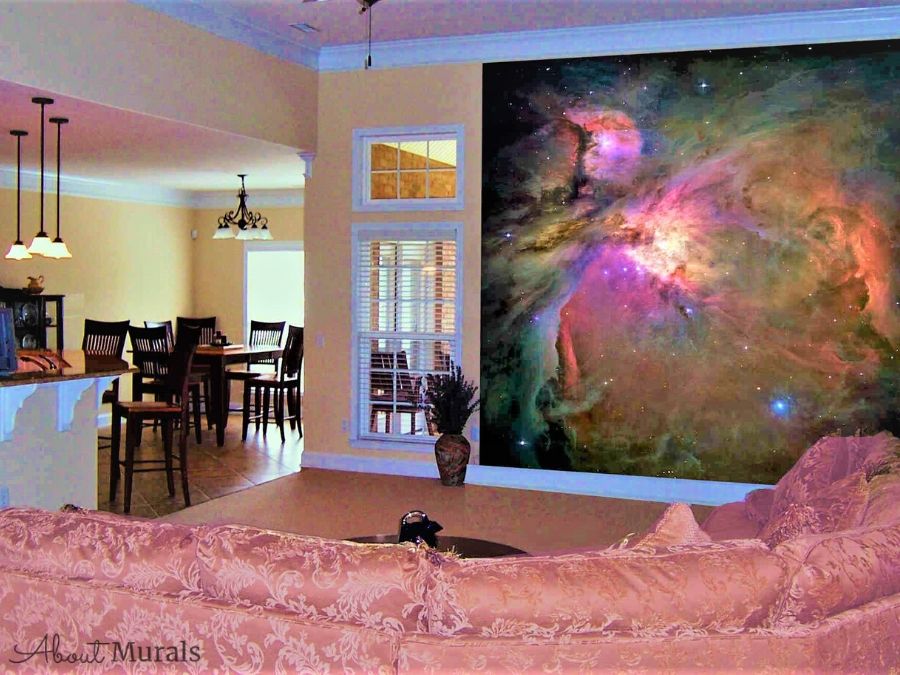Orion Nebula Space Wall Mural, as seen in this living room, features a cloud of purple and orange gas surrounded by 3000 stars in the Milky Way. Space wallpaper sold by AboutMurals.ca.