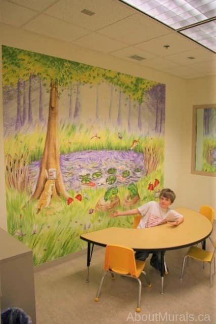 Secret Garden Wall Mural, as seen on the wall of this hospital, features a frog, bunny rabbit, butterfly and dragonfly surrounded by trees and next to a pond. Kids wallpaper sold by AboutMurals.ca.