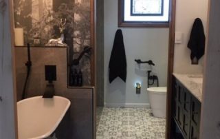 Sinfonia Della Foresta Black and White Wall Mural, as seen in this bathroom, features grey trees in an enchanted forest. Forest wallpaper sold by AboutMurals.ca.