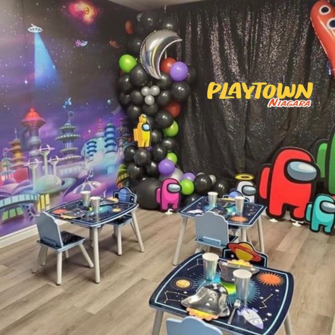 Space City Wall Mural, as seen in this indoor party space called Playtown Niagara, is a space themed wallpaper mural with rocket ships and UFOs flying over towers in outer space from About Murals.