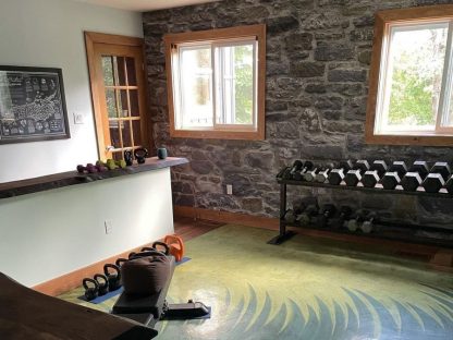Stone Wall Mural, as seen in this home gym, is a photo wallpaper with a stone effect from About Murals.