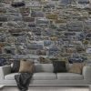 Stone Wall Mural, as seen on the wall of this rustic grey living room, is a photo wallpaper of realistic, textured grey stones with hints of blue and green from About Murals.
