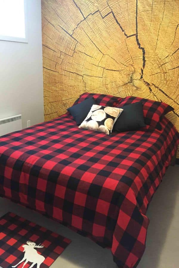 Wood Slab Wallpaper, as seen on the wall of this lumberjack theme bedroom, is a photo mural of a log slice from About Murals.