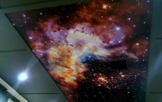 A custom wallpaper, as seen on this ceiling, features a starry outer space sky from About Murals