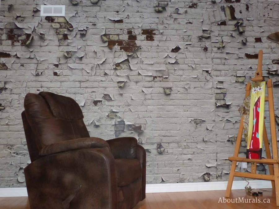 An industrial brick wallpaper with white peeling paint in an artist loft. Sold by AboutMurals.ca