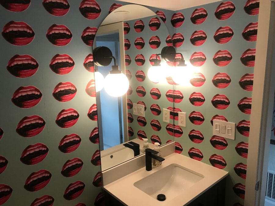 Lips Wallpaper as seen on the wall of this bathroom, is a custom mural wallpaper of red lips on a blue background from About Murals.