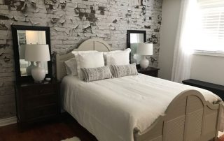 Peeling Paint Brick Wallpaper, as seen in this bedroom, creates a distressed, textured look. White brick wallpaper sold by AboutMurals.ca.