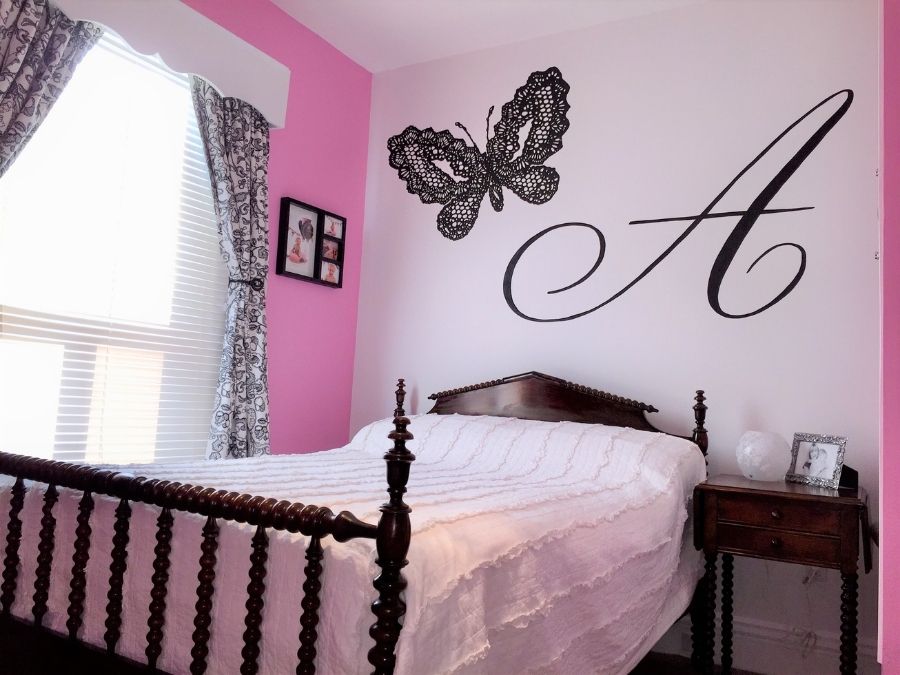 Black Butterfly Mural, as seen on the wall of this girls bedroom, is hand-painted in Hamilton, ON with a lace butterfly and letter "A" from About Murals.
