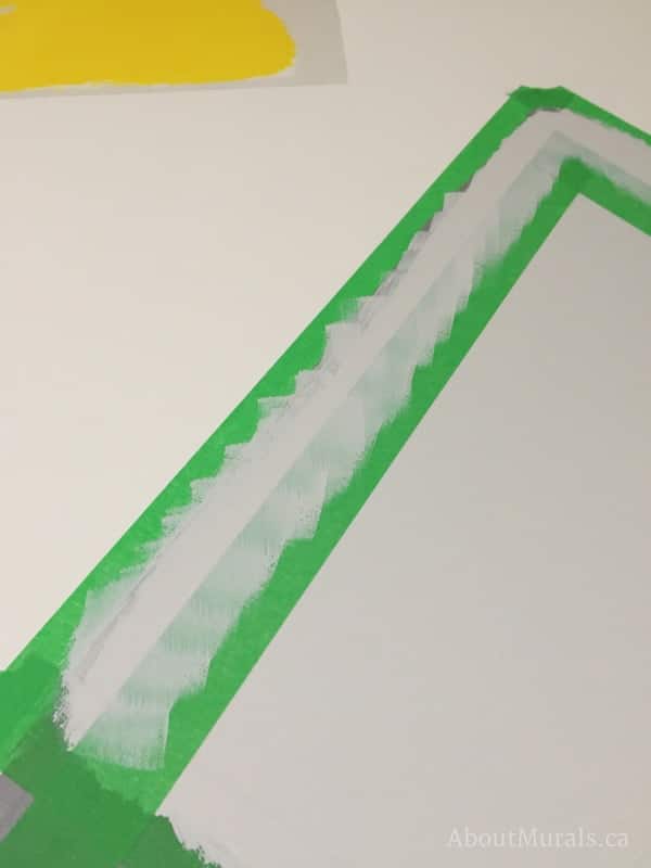 A narrow gap is created with painters tape to outline a mountain mural