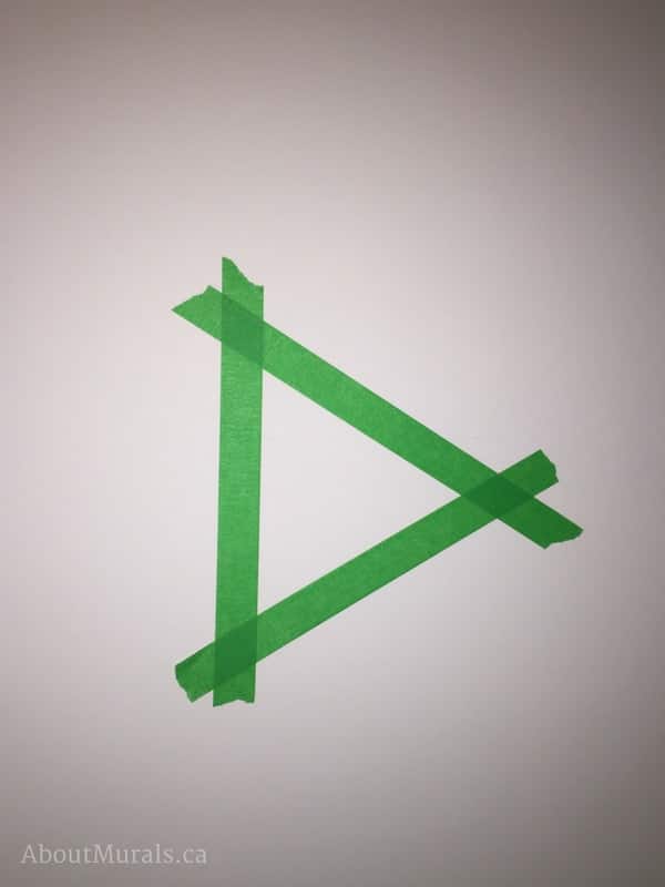A triangular stencil made from green painters tape by muralist Adrienne of AboutMurals.ca