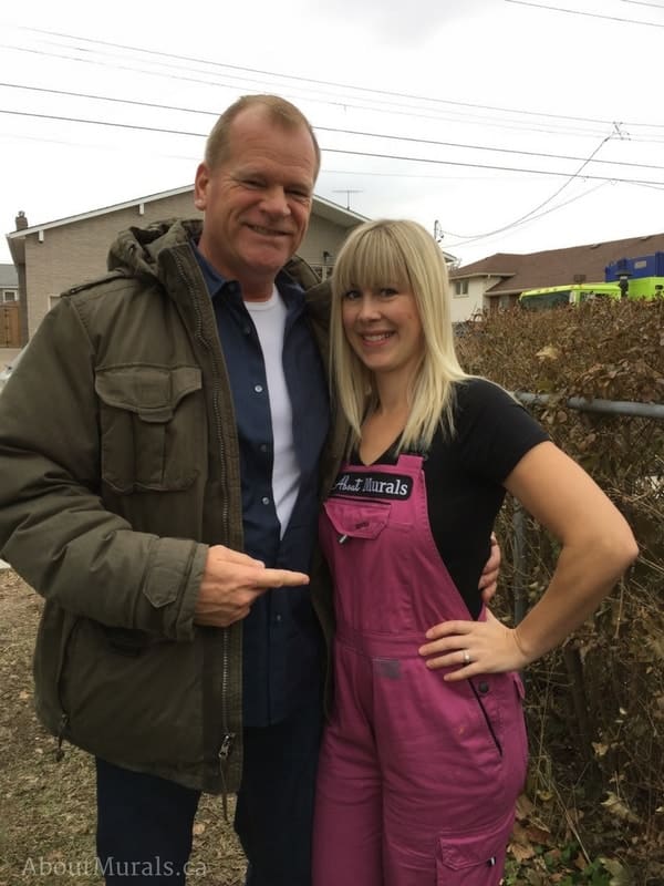 Holmes Next Generation star Mike Holmes stands with Adrienne of AboutMurals.ca after she finished painting a mural for the television show