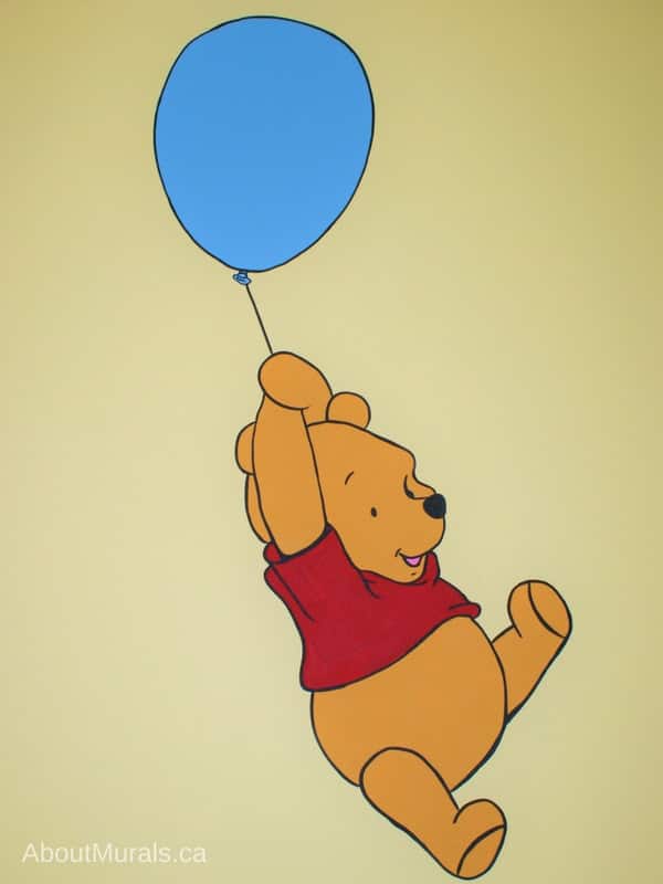 A Winnie the Pooh mural featuring the adorable bear floating by balloon, painted by Adrienne of AboutMurals.ca