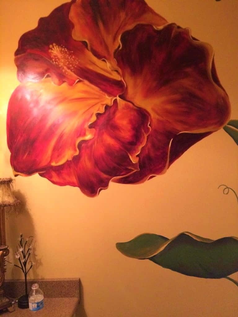A hibiscus mural painted in red and gold colours by Adrienne of AboutMurals.ca