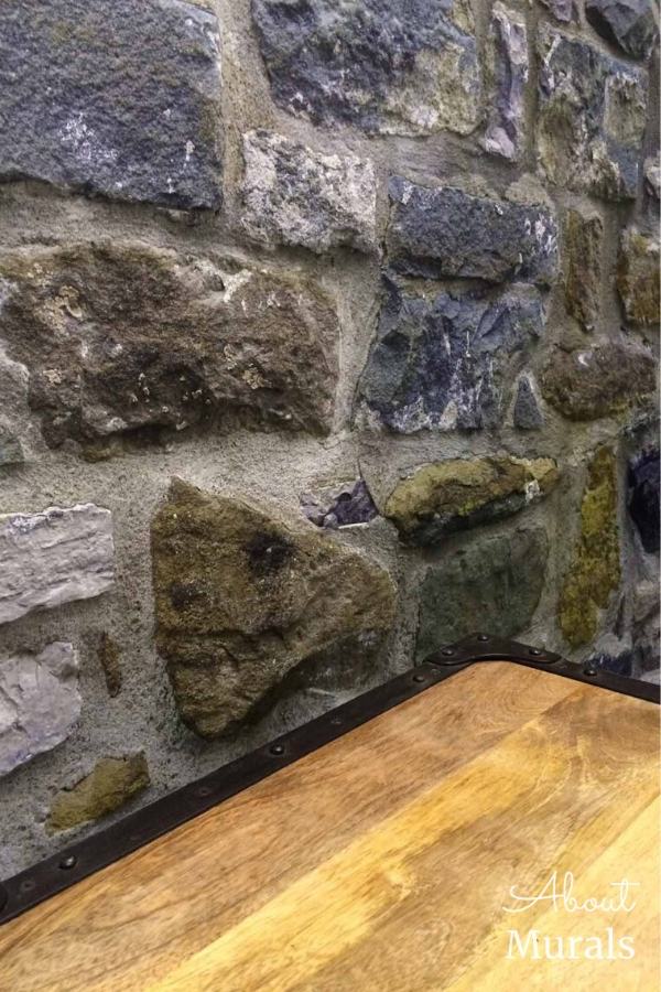 A faux stone wallpaper against a rustic wood shelf