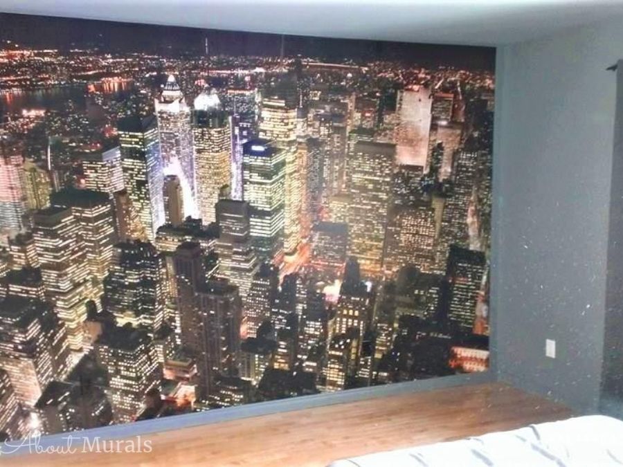 Birds Eye View of Manhattan Wallpaper, as seen on the wall of this bedroom, features skyscrapers in New York. Cityscape wallpaper sold by AboutMurals.ca.