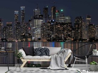Toronto at Night Wallpaper, as seen on the wall of this living room, is a high resolution photo mural of lit up buildings reflected in Lake Ontario under a black sky from About Murals.