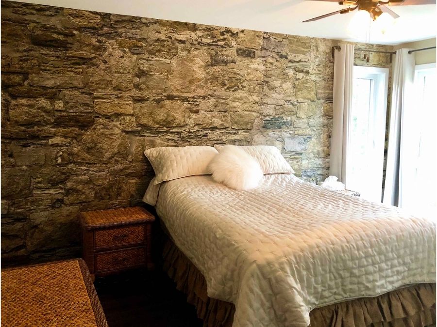 Castle Stone Wallpaper, as seen on the wall of this cozy bedroom, is a photo mural of brown stones from About Murals.