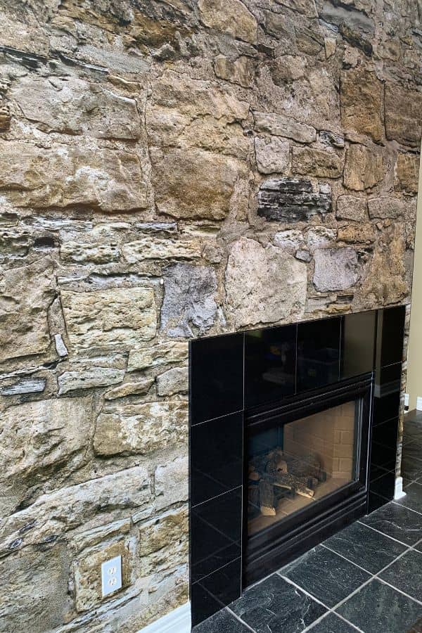 Castle Stone Wallpaper, as seen on this fireplace surround, is a high resolution photo mural of a brown textured stone wall from About Murals.
