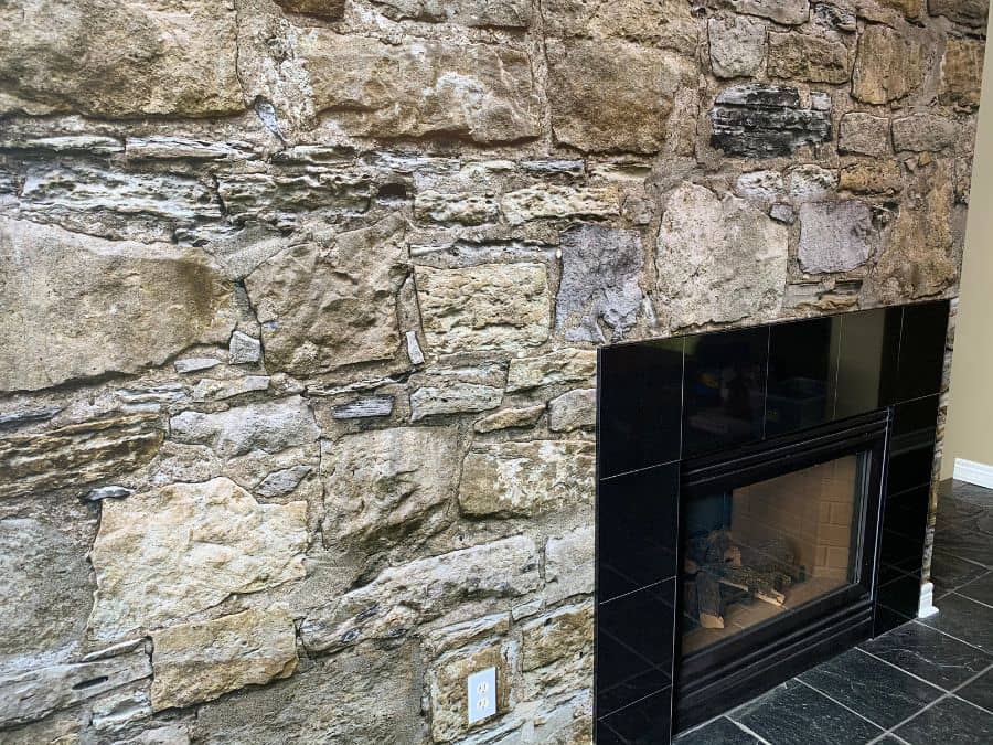 Castle Stone Wallpaper, as seen on the wall surrounding this fireplace, is a high resolution photo mural of realistic, textured brown stacked stones from About Murals.