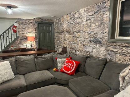 Castle Stone Wallpaper, as seen on the wall of this gray living room, is a high resolution photo mural of realistic beige stones from About Murals.