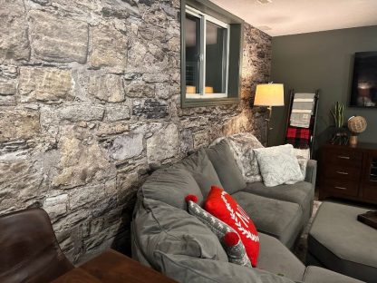 Castle Stone Wallpaper, as seen on the wall of this grey living room, is a high res photo wall mural of realistic stones with tons of texture from About Murals.