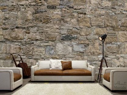 Castle Stone Wallpaper, as seen on the wall of a living room, is a photo mural of a wall of brown rugged rocks. Easy wallpaper sold by About Murals.