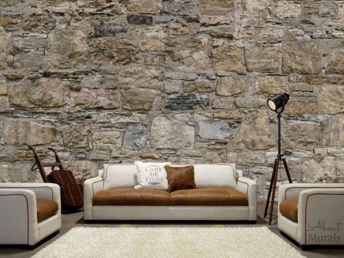 Castle Stone Wallpaper, as seen in a living room, features a wall of brown rugged rocks. Easy wallpaper sold by AboutMurals.ca.